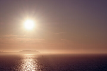 Sunset over an island shrouded with mist