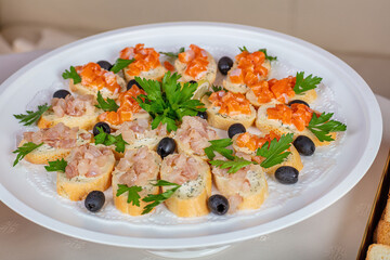 There are sandwiches with salmon and herbs on the plate.