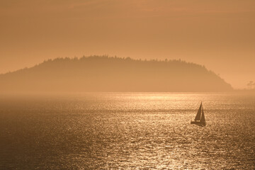 Sailboat in the misty islands at dusk