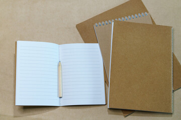 Blank white notepad and pencil on paper background. Mock up, top view, copy space.