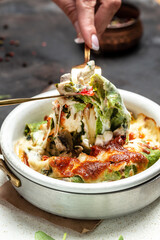 Mediterranean cuisine spinach crepes stuffed with chicken and mushrooms baked with cheese. cooking concept, vertical image. copy space