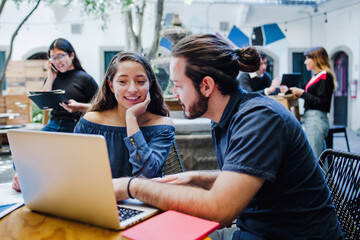 Smiling hispanic college students sitting while taking online class in Latin America