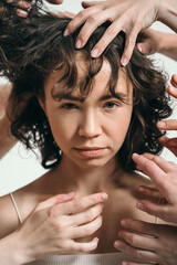 Obraz premium Black and white portrait of a beautiful girl. Lots of hands around a woman's face. Creative portrait of the original woman