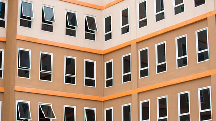 Close-up view of brown and orange campus building with multiple glass windows