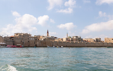 Obraz premium View from the boat to the Mediterranean Sea, the fortress wall and buildings in the old city of Acre in northern Israel