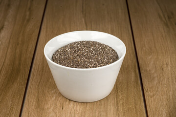 Tazón de cerámica blanca con semilla de chia sobre madera