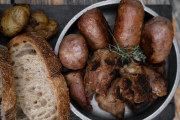 Barbecue. Traditional asado criollo plate. Top view of chorizos, pork sausages, grilled sweetbreads, potatoes and bread.