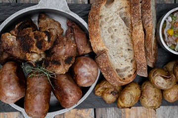 Barbecue. Traditional asado criollo plate. Top view of chorizos, pork sausages, grilled sweetbreads, potatoes and bread.