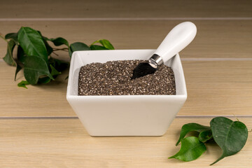 Tazón de cerámica blanca con semilla de chia sobre madera