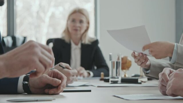 Slowmo PAN Midsection Shot Of Unrecognizable Businessman Giving Pile Of Legal Documents To Female Lawyer Or Attorney For Checking During Negotiations With Investor