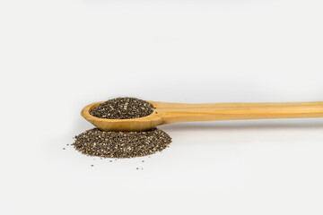 Cuchara de madera con semilla de chia y fondo blanco