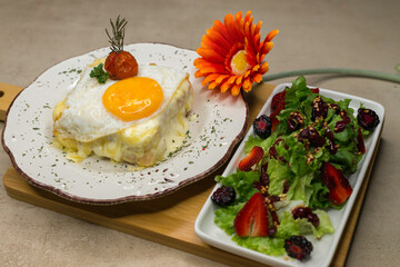 Sandwich croque madame con queso fundido y huevo estrellado