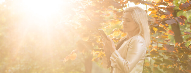 Young woman using mobile phone in park outdoor. Technology lifestyle. People virtual connection.