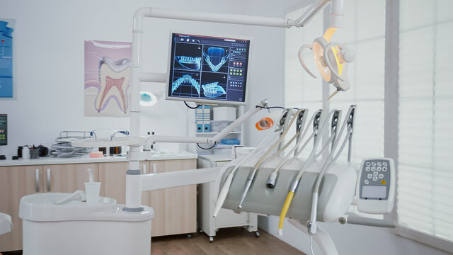 Revealing shot of orthodontist chair with nobody in, dental x ray images on display. Clinic stomatology hospital room, ready for medical treatment, modern dentist office prepared for oral care