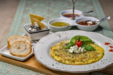 Desayuno especial de omelette de huevo revuelto acompañado de aguacate, frijoles refritos, pan y variedad de salsas