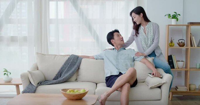 Happy young couple sitting on sofa,4K