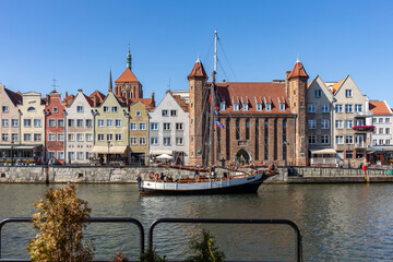 Fototapeta na wymiar Old town of Gdansk with the Mariacka Gate and a promenade along the riverbank of Motlawa River
