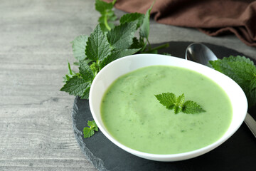 Concept of healthy food with nettle soup on gray textured table