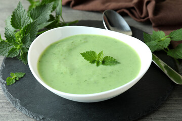 Concept of healthy food with nettle soup on gray textured table