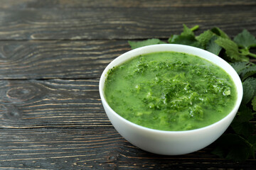 Concept of healthy food with nettle soup on wooden table