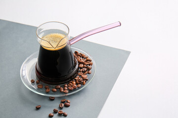 Turkish coffee in cezve and beans on light background