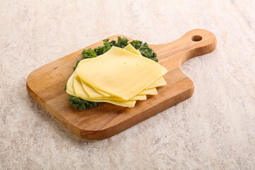 Sliced Gouda cheese over board