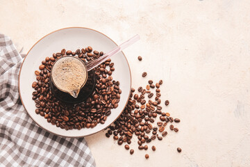 Turkish coffee in cezve and beans on light background