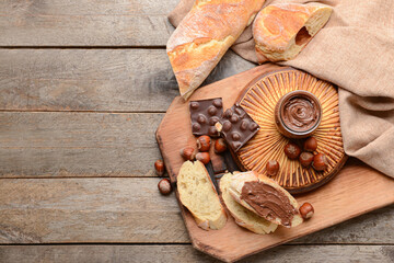 Composition with tasty chocolate paste and hazelnuts on wooden background