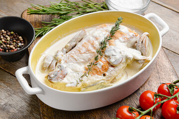 Baking dish with tasty chicken fillet on wooden background