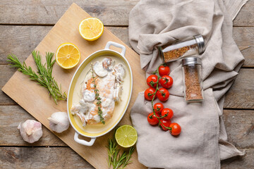 Baking dish with tasty chicken fillet on wooden background