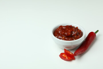 Red chili pepper and sauce on white background