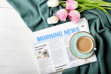 Morning newspaper with cup of coffee and tulip flowers on white background