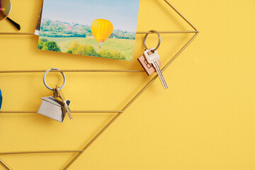 Holder with keys and picture hanging on color wall - Powered by Adobe