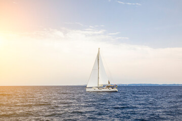 Fototapeta na wymiar Yacht sailing at sunset during a storm. Luxury vacation at sea
