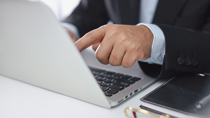 Man hands in black suit sitting and using computer for online payment or shopping online. Business man touching monitor while working. E-Banking concept