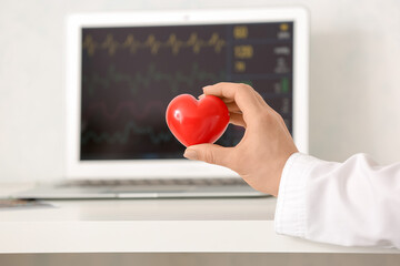 Female cardiologist with red heart in clinic
