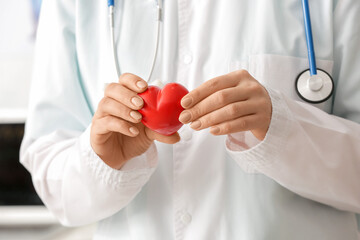 Female cardiologist with red heart, closeup