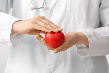 Female cardiologist with red heart, closeup