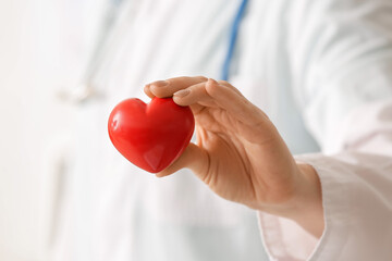 Female cardiologist with red heart, closeup