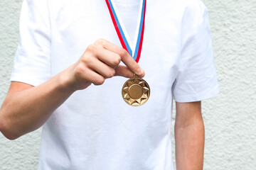 Gold medal in the boy hand. Sport concept.