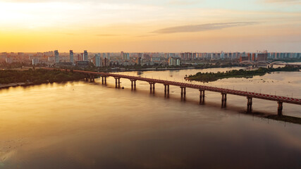 Fototapeta na wymiar Dawn in a modern city overlooking the bridge over the river