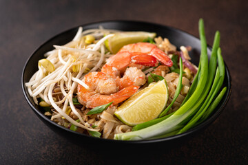 Pad Thai with shrimp on a stone background, selective focus