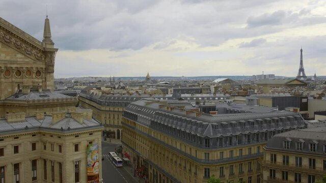 Rear Exterior Of Opera Garnier (Palais Garnier) As Viewed From Galeries Lafayette In Paris, France With Eiffel Tower In Far Distance. aerial and cinematic