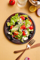 Plate with tasty Greek salad on color background