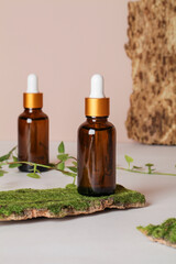 dark amber glass bottle with oil on natural bark with leaf on beige background. copy space. Beauty concept, minimalism brand packaging mock up.