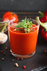Glass with tasty gazpacho on dark background, closeup