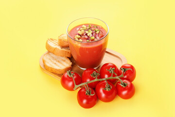 Glass with tasty gazpacho on color background