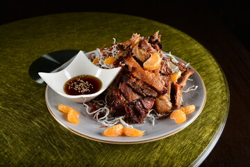 asian premium banquet menu bbq duck confit meat with mandarin orange sauce on gold background dining table