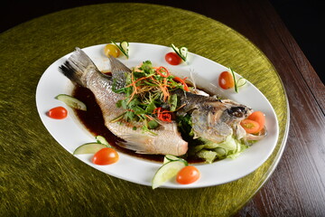 asian premium banquet menu chinese steamed big fresh whole grouper fish in dark soy sauce on gold background dining table