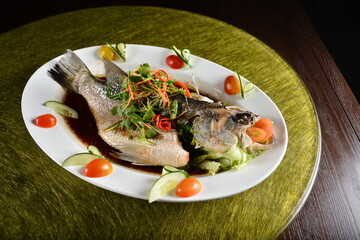 asian premium banquet menu chinese steamed big fresh whole grouper fish in dark soy sauce on gold background dining table